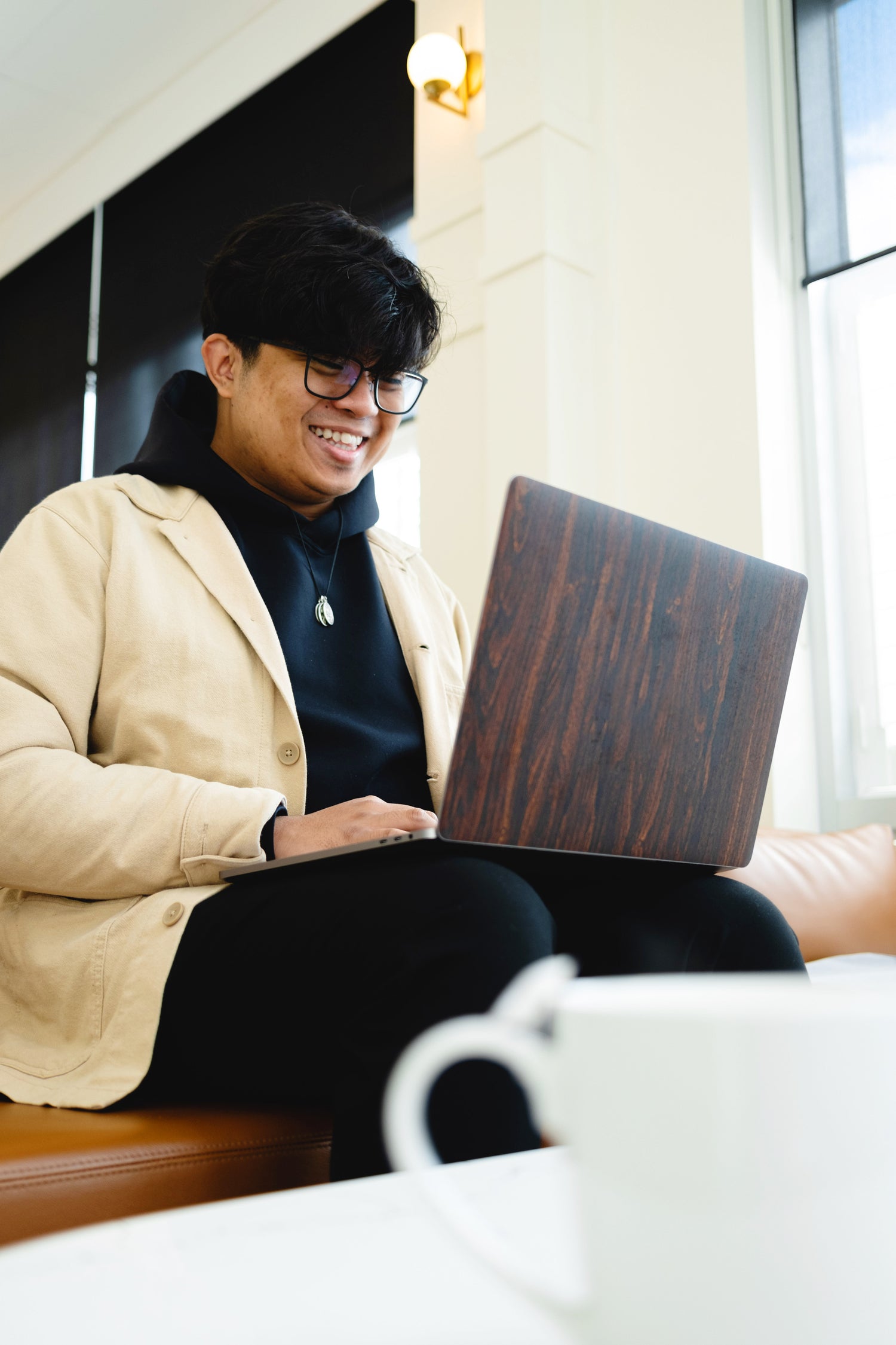 Man smiling and looking at laptop screen.